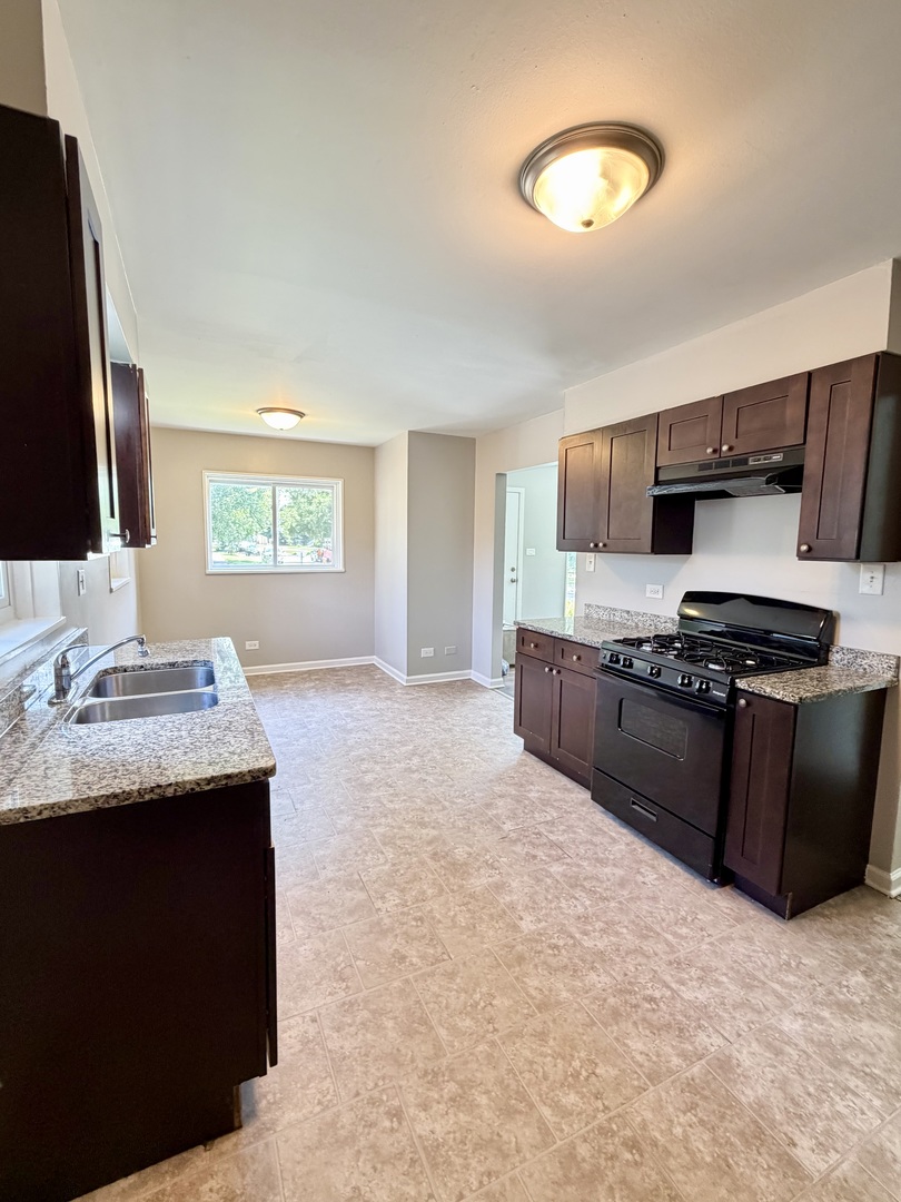 1820 169th Street Hazel Crest, IL 60429 - Photo 13 of 23 a kitchen with stainless steel appliances granite countertop a sink and a stove