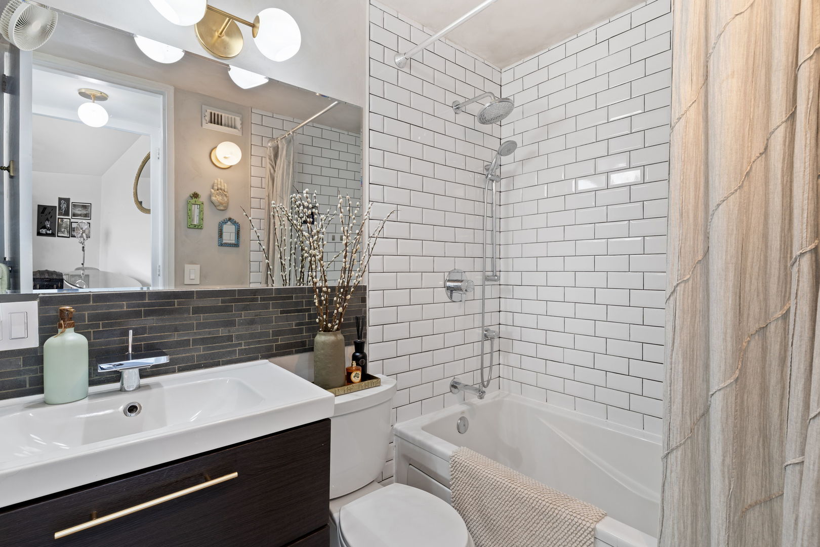 720 West Gordon Terrace, Unit 15N Chicago, IL 60613 - Photo 10 of 22 a bathroom with a bathtub sink vanity mirror and toilet