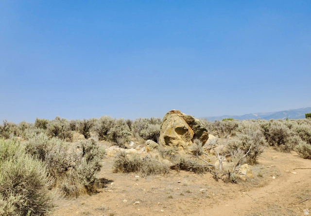 Undisclosed Address Spring City, UT 84662 - Photo 2 of 19 Expansive natural landscape with native brush, exposed rock formations, and a clear blue sky overhead