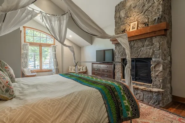 a spacious bedroom with a bed a table and chair