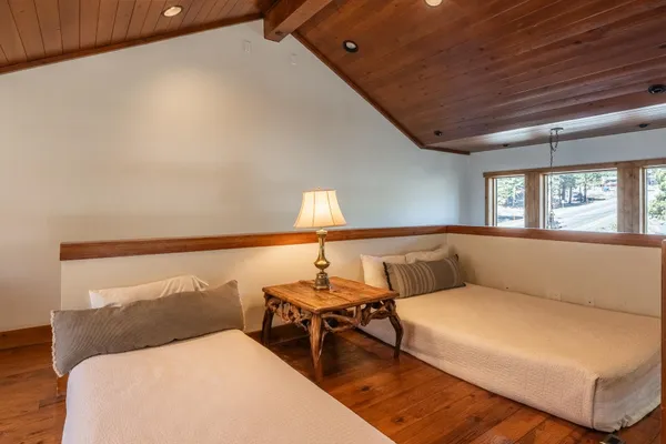 a view of a bedroom with wooden floor and windows