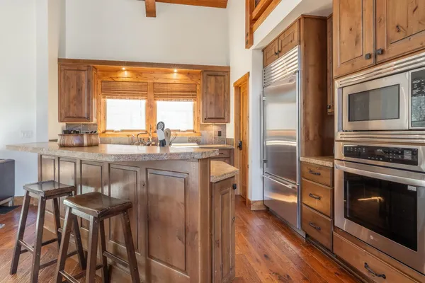 a kitchen with stainless steel appliances granite countertop a stove a sink and a refrigerator