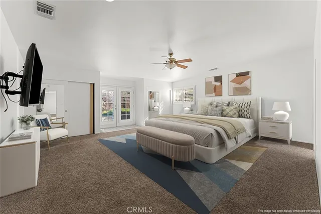 a bedroom with a large bed and a flat screen tv