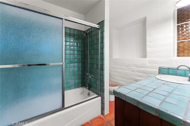 a bathroom with a granite countertop sink a toilet and shower