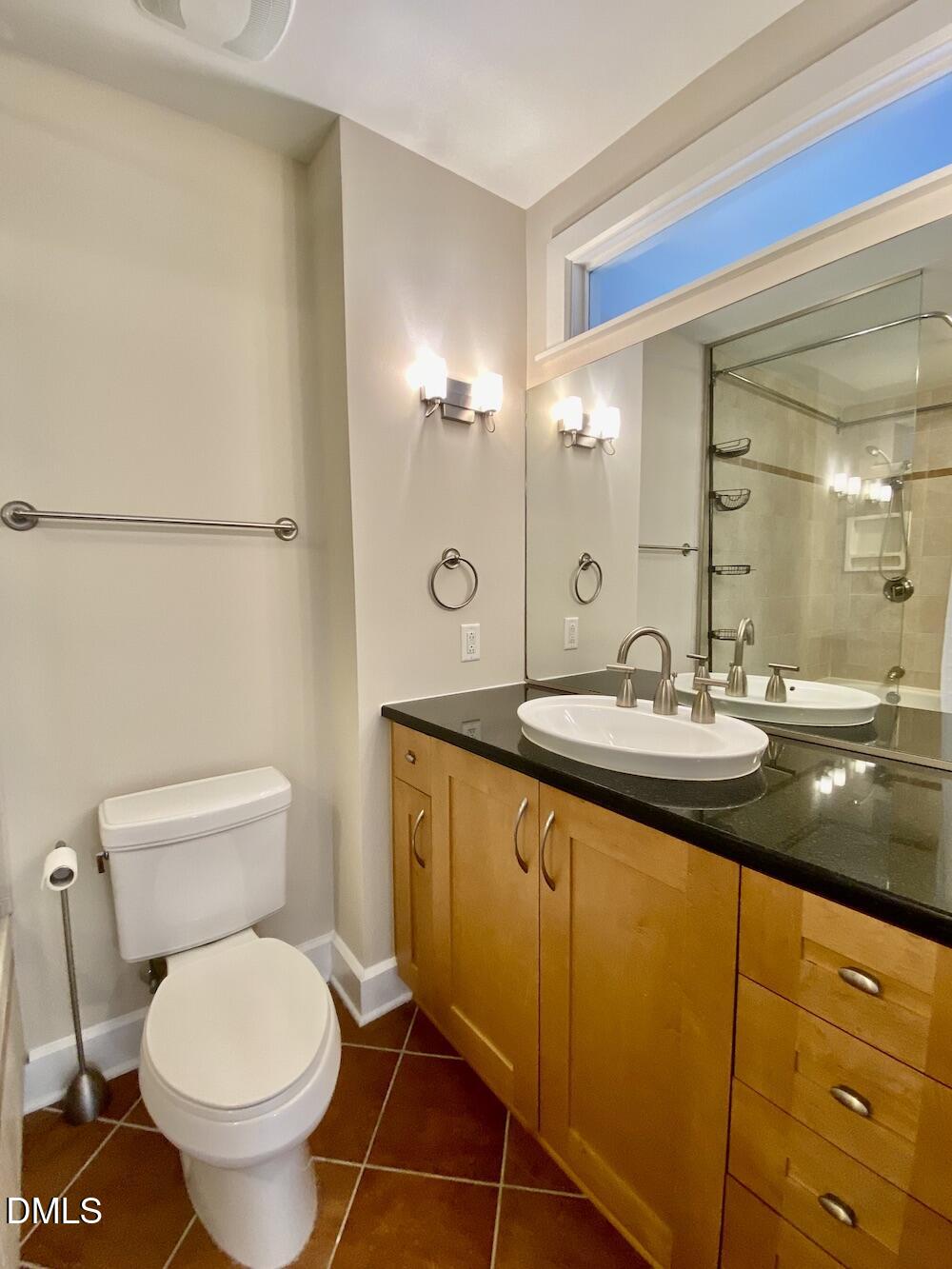 2608 Erwin Road, Unit 428 Durham, NC 27705 - Photo 19 of 33 a bathroom with a granite countertop toilet a sink and a mirror