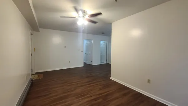 an empty room with wooden floor and windows
