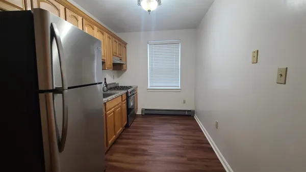 a view of a refrigerator in kitchen and wooden floor