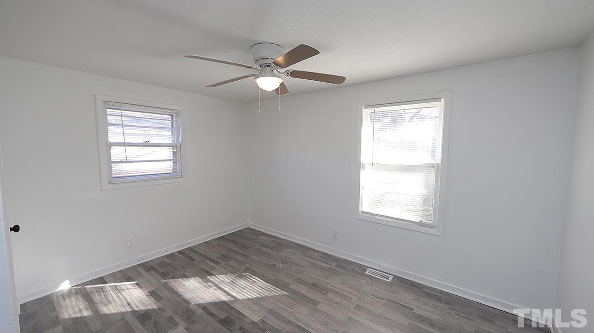 820 Cross Link Road Raleigh, NC 27610 - Photo 8 of 13 an empty room with a window and ceiling fan