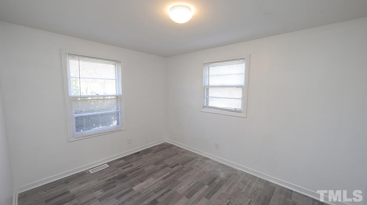 820 Cross Link Road Raleigh, NC 27610 - Photo 9 of 13 an empty room with wooden floor and windows