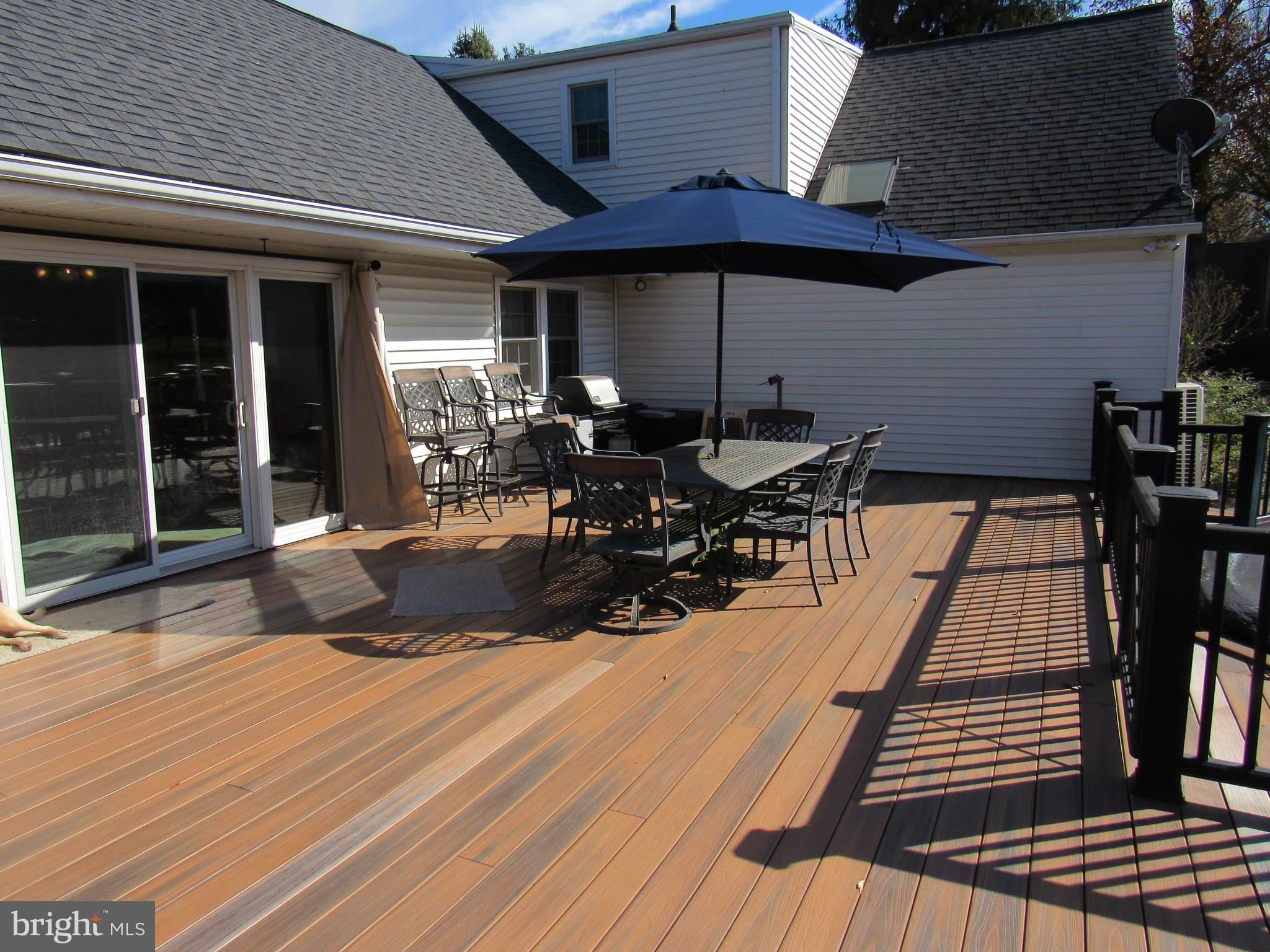 48 Ridge Road Phoenixville, PA 19460 - Photo 20 of 54 a view of a patio with table and chairs under an umbrella with wooden floor