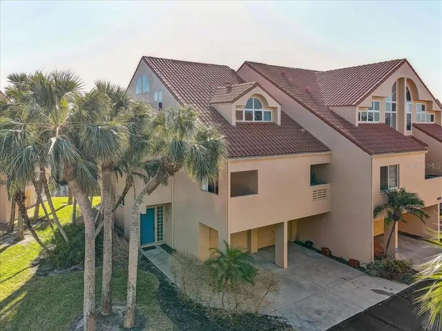 a front view of a house with a yard and potted plants