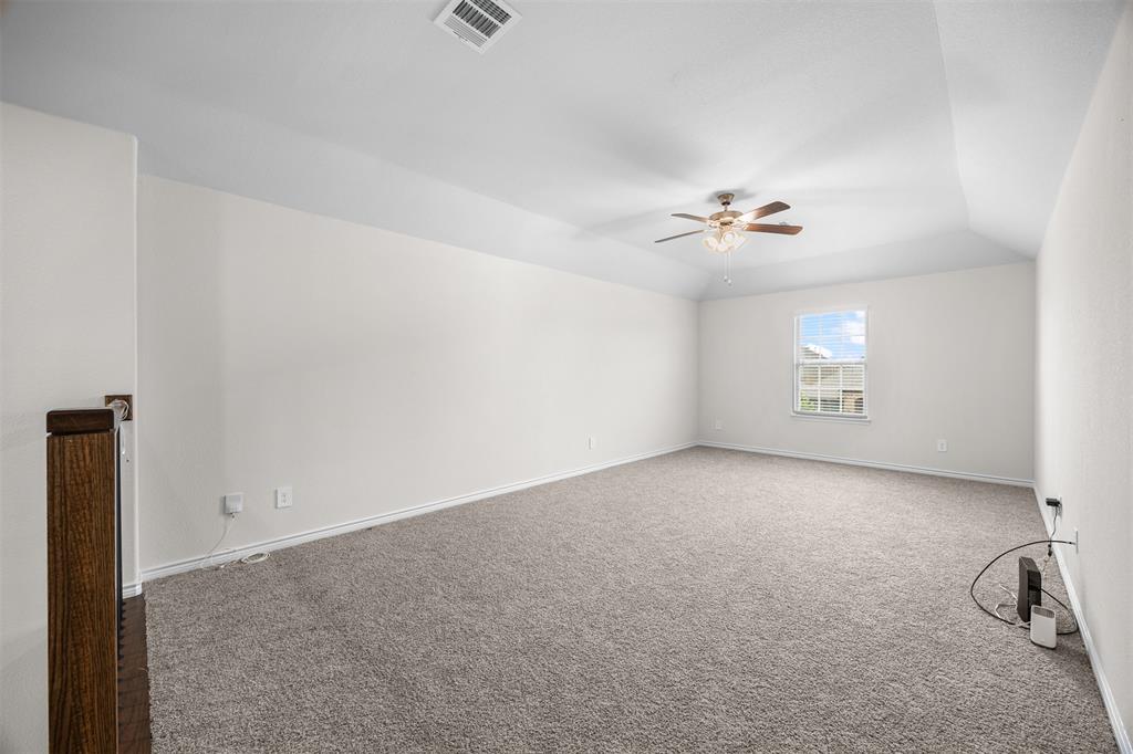 3808 High Country Road Aubrey, TX 76227 - Photo 21 of 36 Spacious room featuring vaulted ceilings, a single window, a ceiling fan with light fixture, and plush carpet flooring