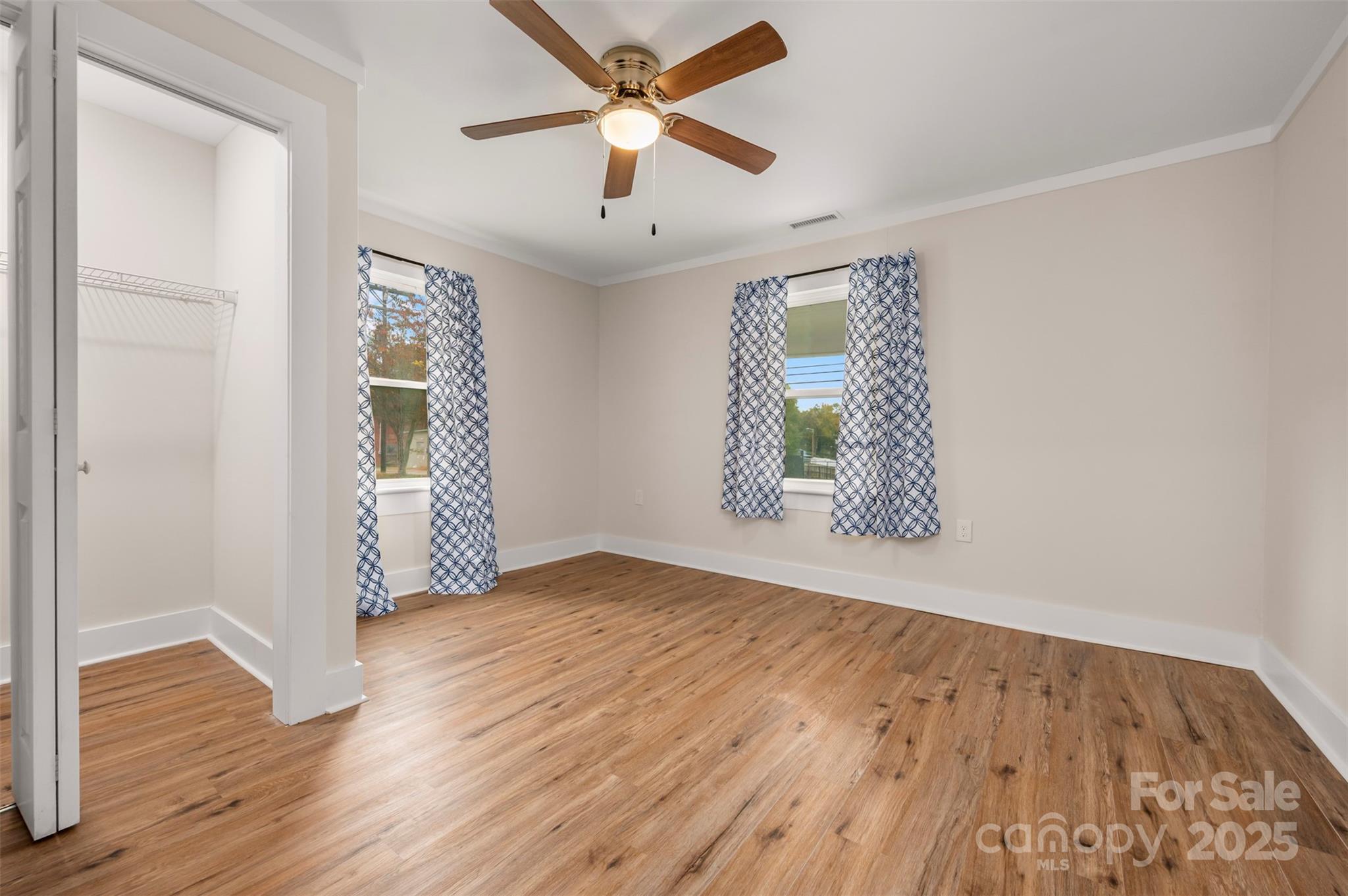 512 Spindale Street Spindale, NC 28160 - Photo 18 of 25 an empty room with wooden floor chandelier fan and windows