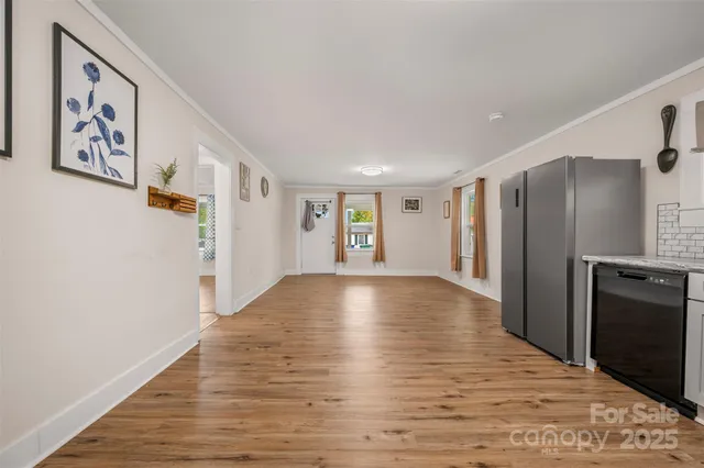 a view of an empty room with window and refrigerator