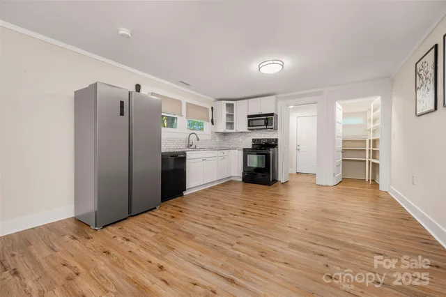 a kitchen with stainless steel appliances a refrigerator and wooden floor