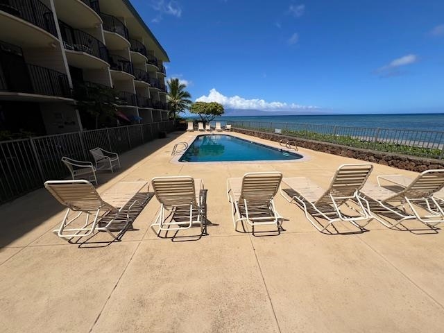 4471 Lower Honoapiilani Road, Unit 202 Lahaina, HI 96761 - Photo 13 of 24 a view of a patio with table and chairs with wooden floor and fence