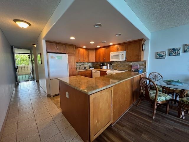 4471 Lower Honoapiilani Road, Unit 202 Lahaina, HI 96761 - Photo 5 of 24 a kitchen with stainless steel appliances granite countertop a refrigerator a oven a sink and a dining table