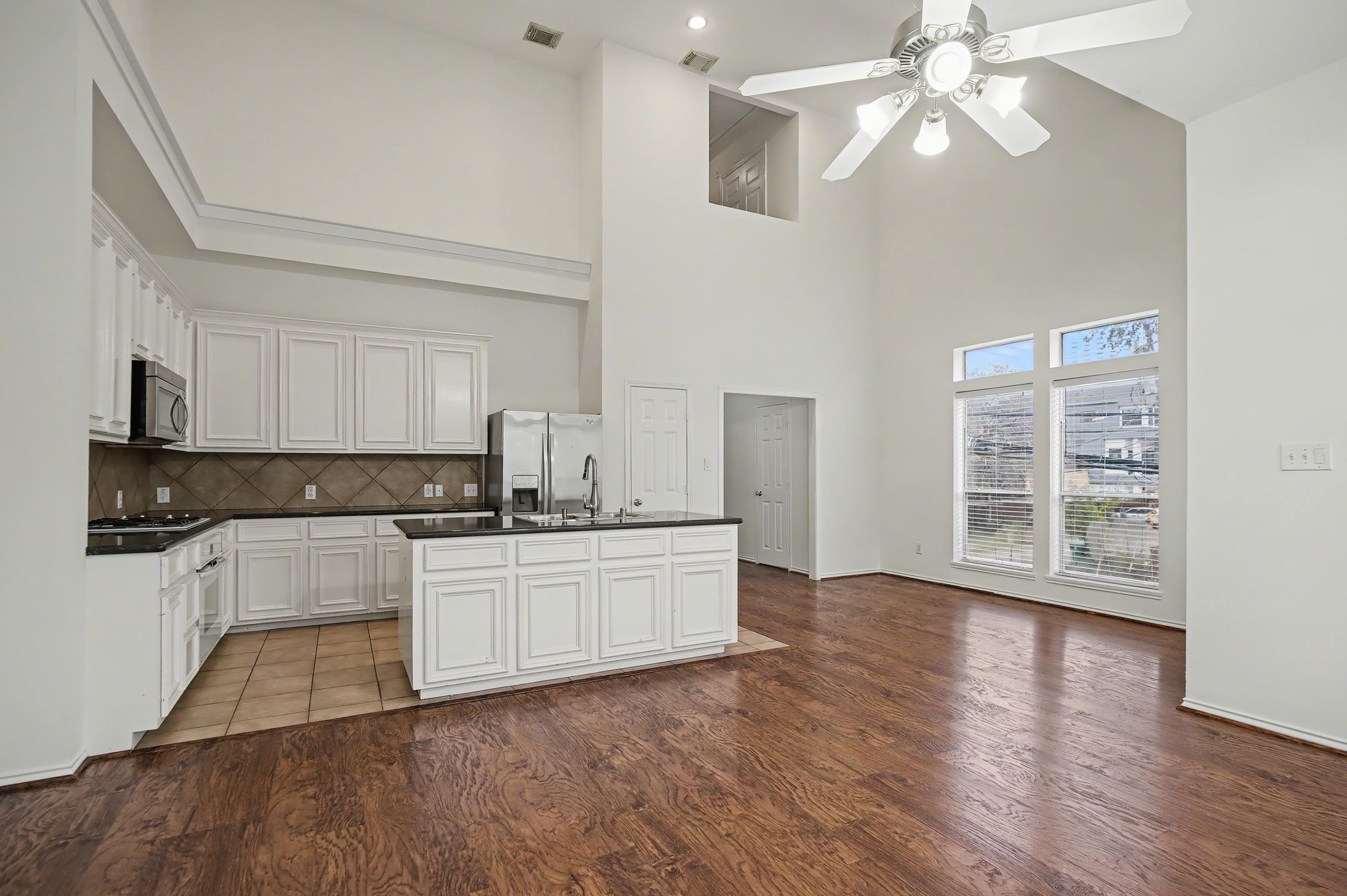 2416 Charleston Street, Unit A Houston, TX 77021 - Photo 6 of 24 a kitchen with stainless steel appliances granite countertop a stove top oven a chimney cabinets and wooden floor