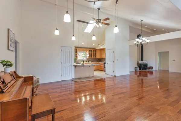 a view of a dining room and livingroom with furniture wooden floor a chandelier