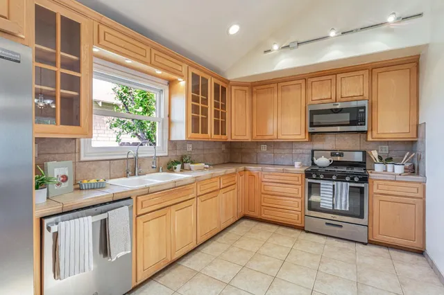 a kitchen with stainless steel appliances granite countertop a stove sink and microwave