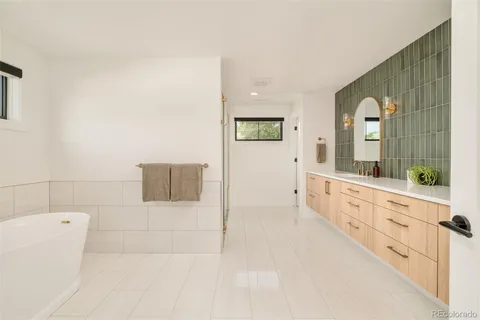 a large bathroom with a tub sink and mirror