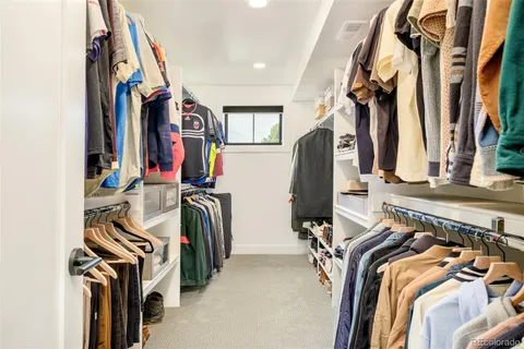 a view of walk in closet with clothes and shoes
