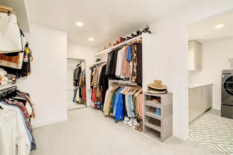 a view of walk in closet with clothes and shoes