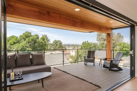 a roof deck with couches and wooden floor