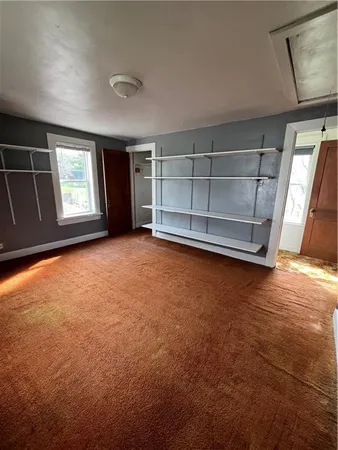 an empty room with a ceiling fan and a window