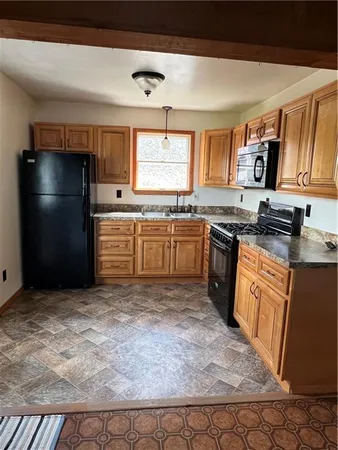 a kitchen with stainless steel appliances granite countertop a stove top oven a sink dishwasher and a refrigerator