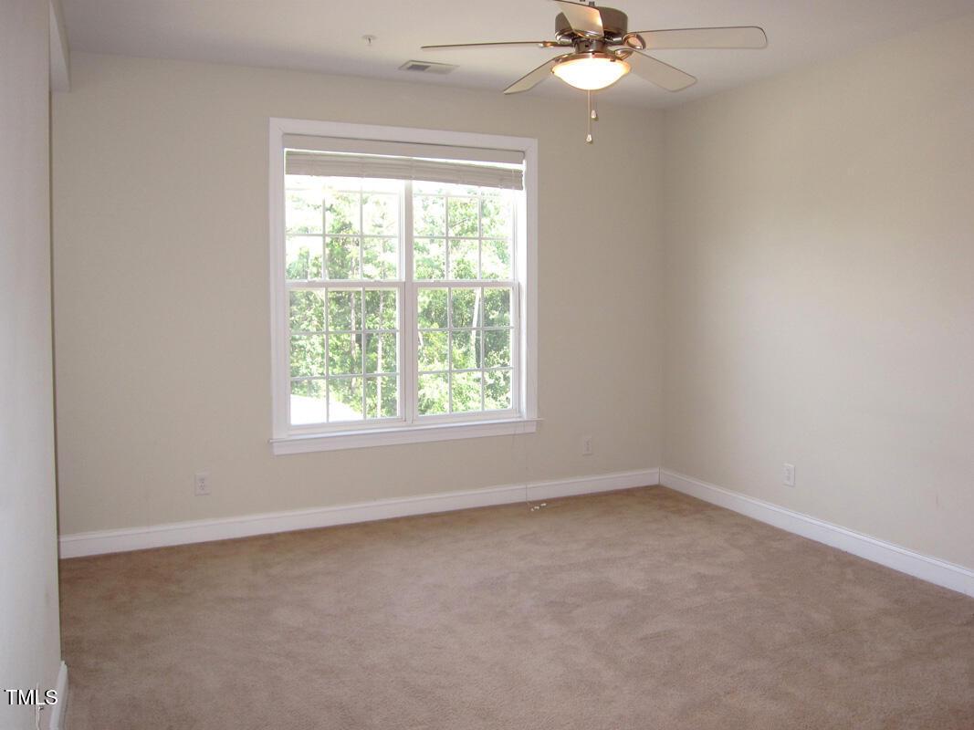 831 Providence Glen Drive Chapel Hill, NC 27514 - Photo 8 of 14 an empty room with a window and a fan