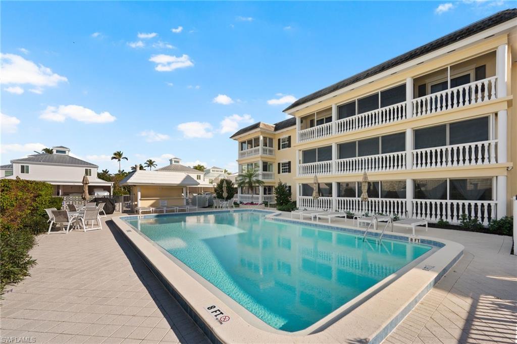 666 3rd Street South, Unit 106 Naples, FL 34102 - Photo 25 of 32 a view of a swimming pool with a lounge chairs