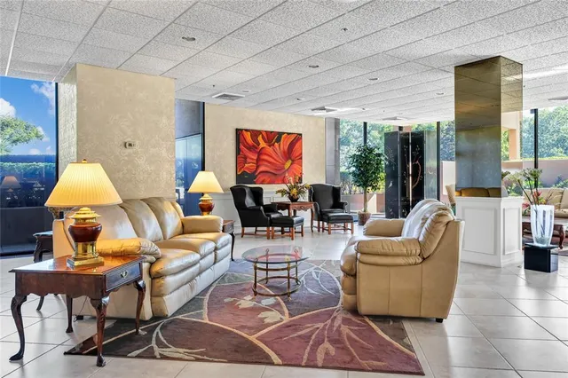 a living room with lots of furniture a rug and a chandelier