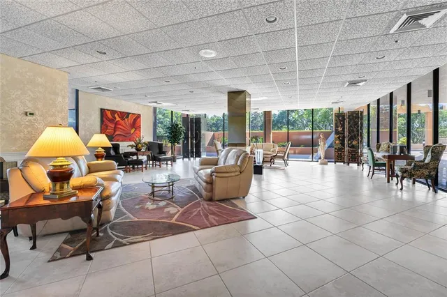 a living room with furniture a table and a large window