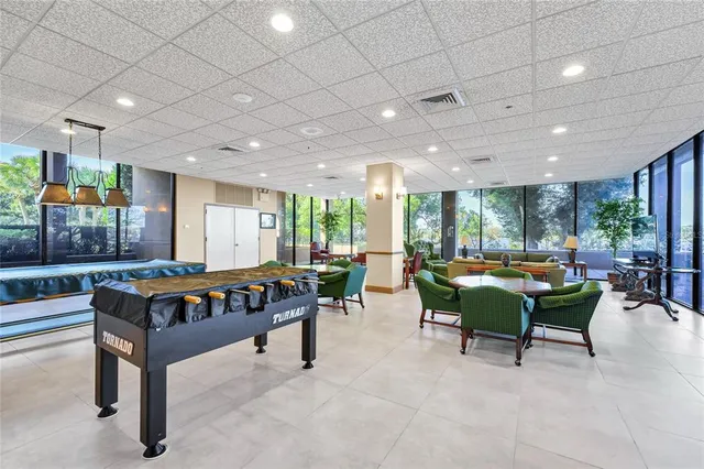 a room with lots of tables a large window and chairs