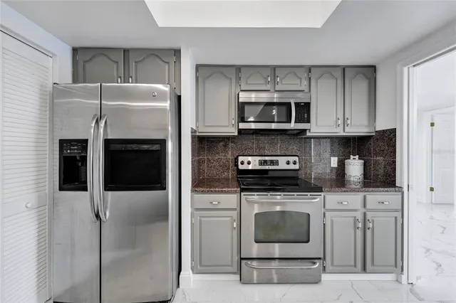 a kitchen with granite countertop a sink stainless steel appliances and cabinets