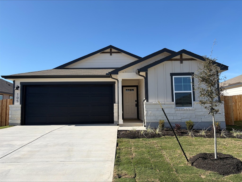 Ranch-style house with driveway, board and batten siding, a garage, and roof with shingles