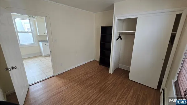 an empty room with wooden floor and a sink