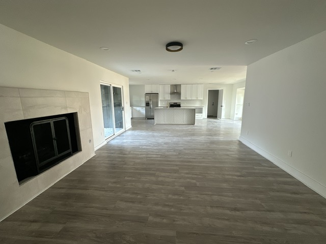 2101 Vanderbilt Lane Austin, TX 78723 - Photo 18 of 25 Unfurnished living room with a tile fireplace and dark wood-type flooring