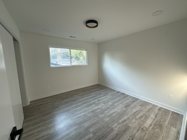 2101 Vanderbilt Lane Austin, TX 78723 - Photo 21 of 25 Unfurnished bedroom with a closet and wood finished floors