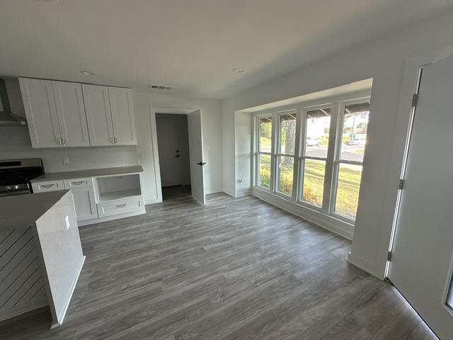 2101 Vanderbilt Lane Austin, TX 78723 - Photo 24 of 25 Kitchen with white cabinets, ventilation hood, dark wood finished floors, stainless steel stove, and recessed lighting