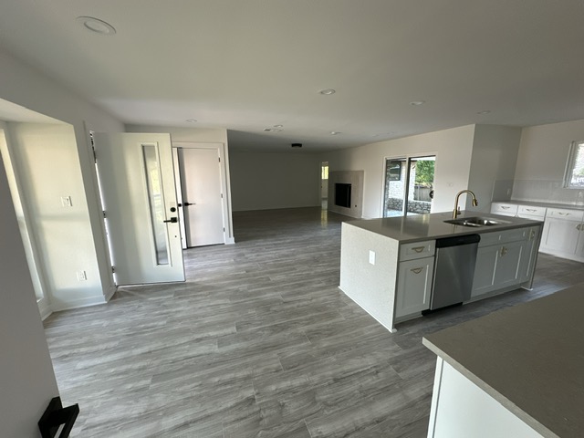 2101 Vanderbilt Lane Austin, TX 78723 - Photo 25 of 25 Kitchen featuring white cabinetry, an island with sink, stainless steel dishwasher, open floor plan, and recessed lighting