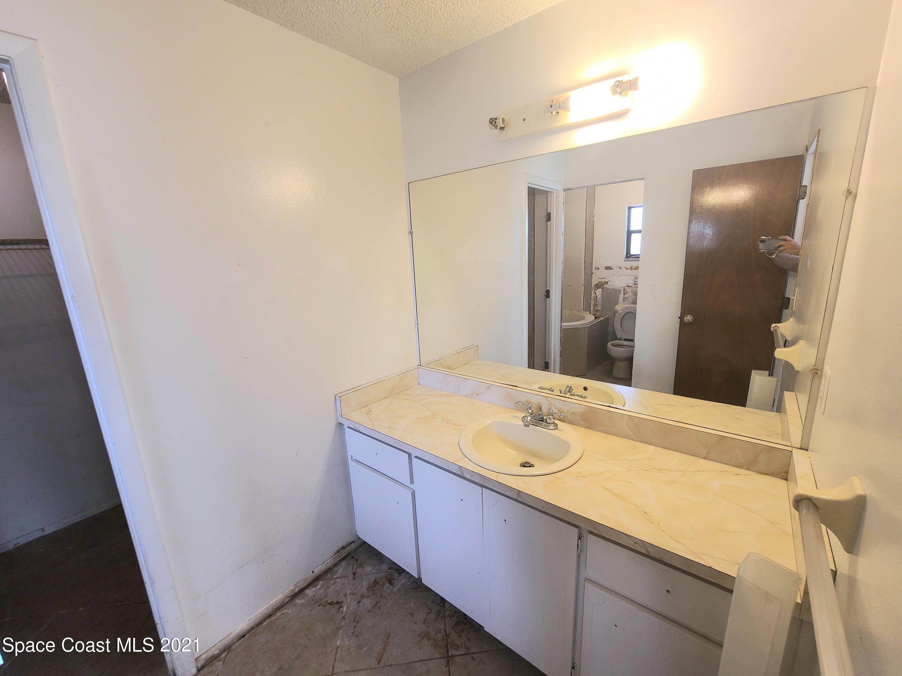 292 Chase Road Cocoa, FL 32927 - Photo 11 of 17 a bathroom with a granite countertop sink and a mirror