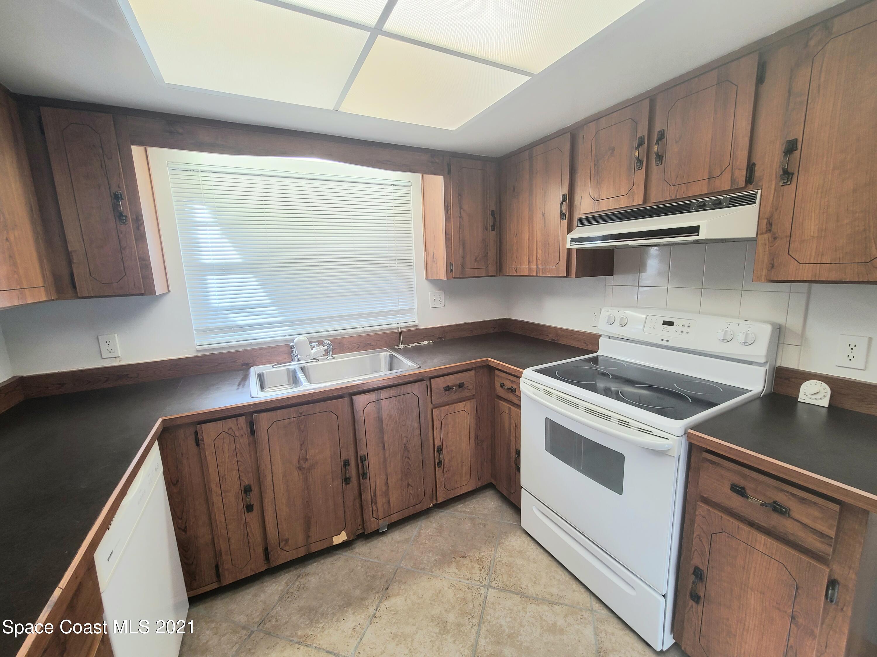 292 Chase Road Cocoa, FL 32927 - Photo 3 of 17 a kitchen with granite countertop white cabinets and white appliances