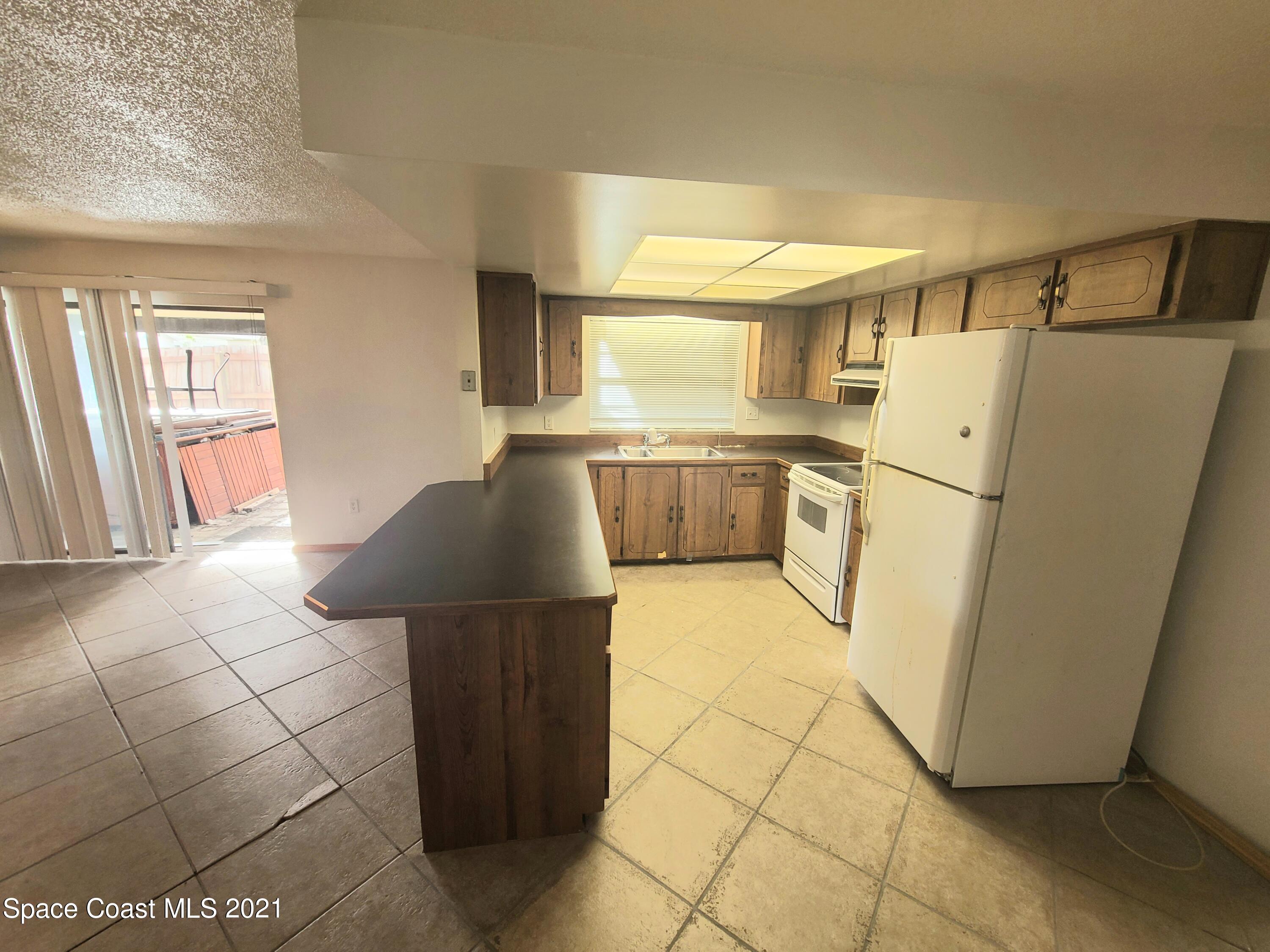 292 Chase Road Cocoa, FL 32927 - Photo 5 of 17 a kitchen with stainless steel appliances granite countertop a refrigerator and a stove