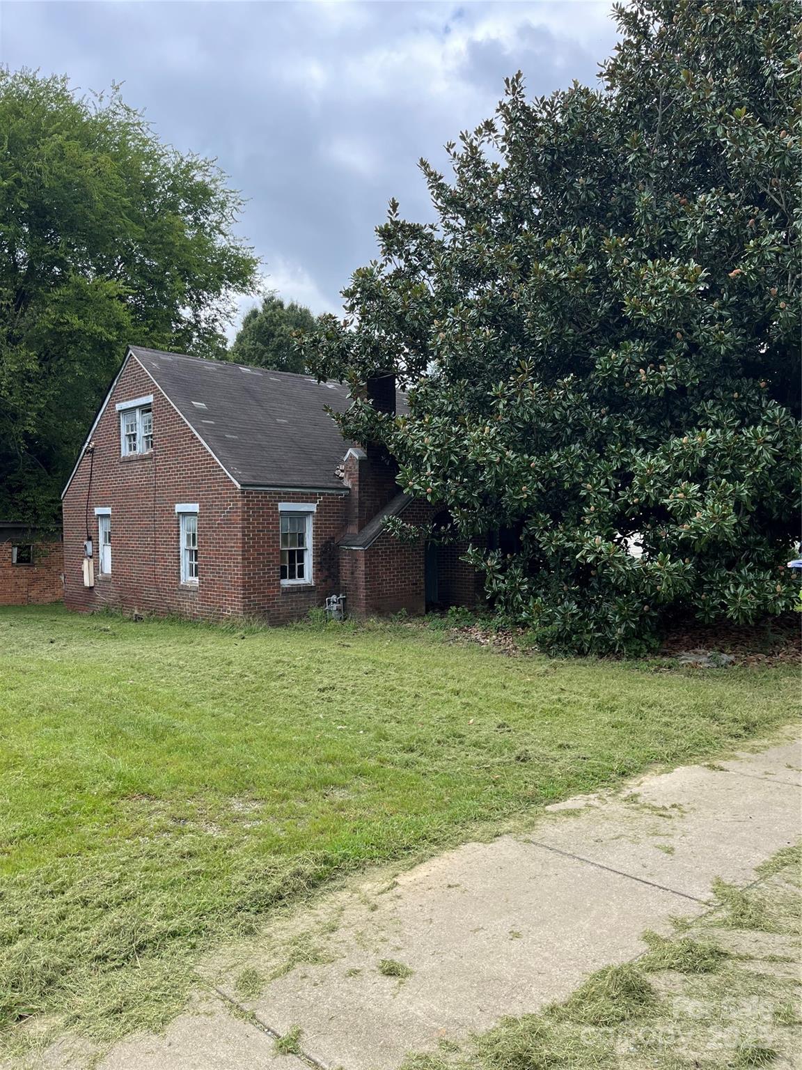 a aerial view of a house next to a yard and a large tree