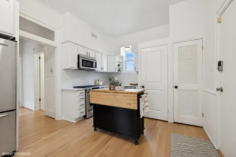 a view of kitchen with stainless steel appliances cabinets and wooden floor