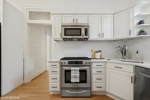 a kitchen with white cabinets and stainless steel appliances