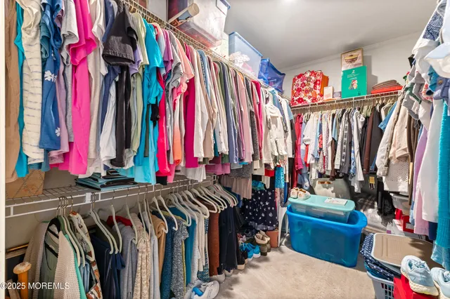 a view of walk in closet with clothes