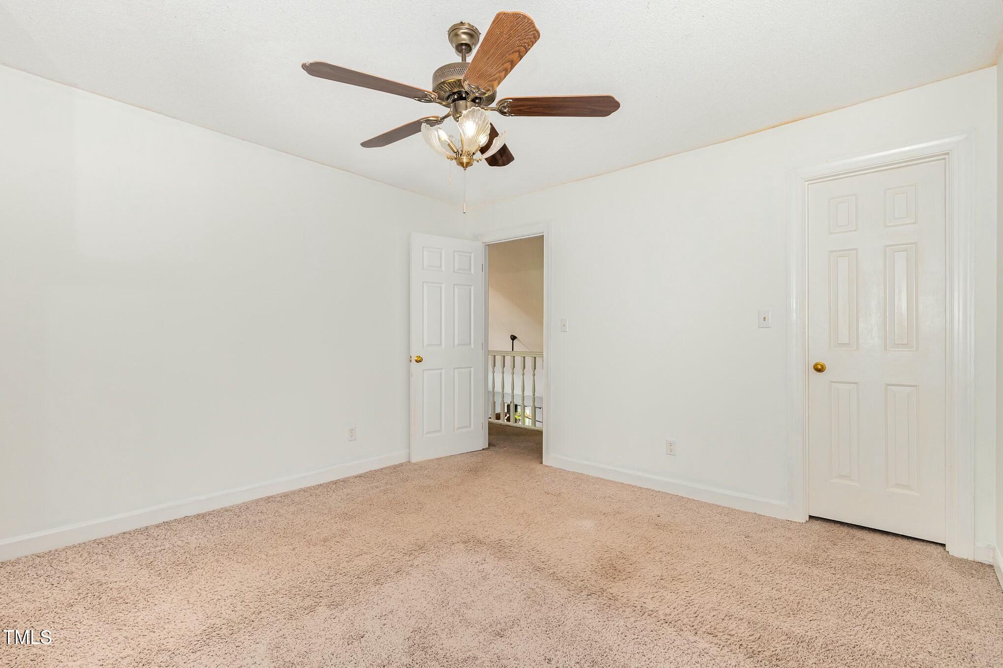 3109 East Folkestone Place Raleigh, NC 27604 - Photo 16 of 25 an empty room with a chandelier fan and wooden floor